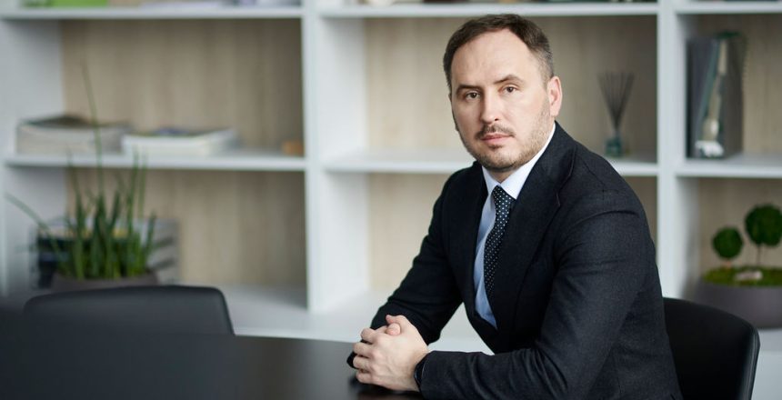 Lietuvos centrinės kredito unijos administracijos vadovas ir valdybos pirmininkas biuro aplinko sėdi prie stalo ir žvelgia į kamerą.